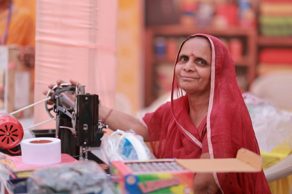 pexels photo 36739505 36739505 A Rajasthani woman in a red saree sewing, symbolizing empowerment and self-reliance.